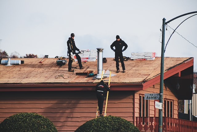 An expert team performing roof inspection with tools